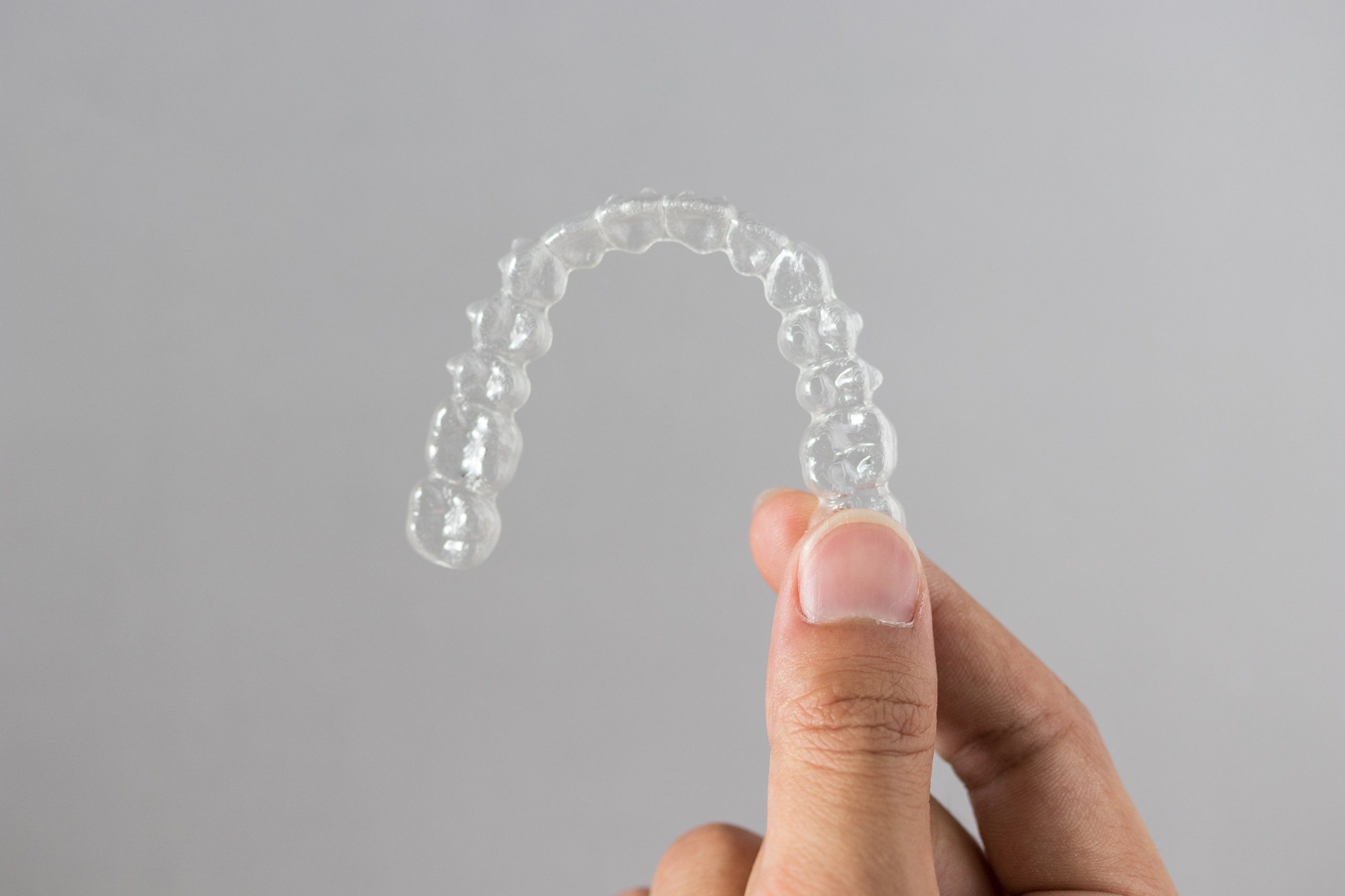 Hands holding clear Invisalign aligners